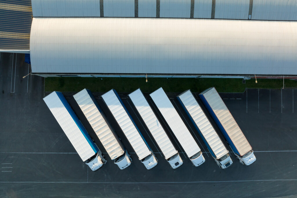 Overhead view of a large warehouse with semi trucks lined up